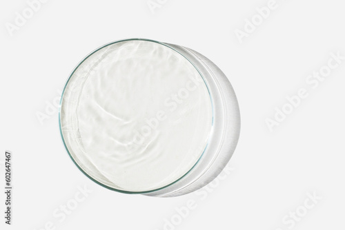Petri dish on a light background with liquid, water. Splashes of water. The waves in the Petri dish. View from above. Laboratory