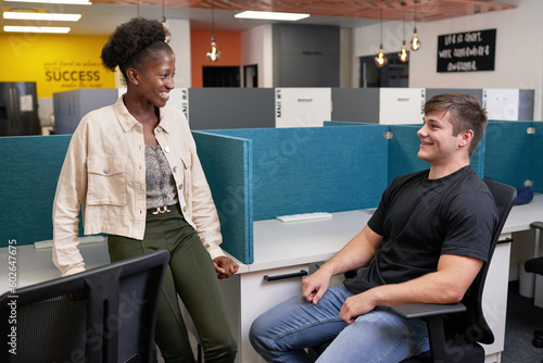 Two young college students relax in the library, talking and chatting