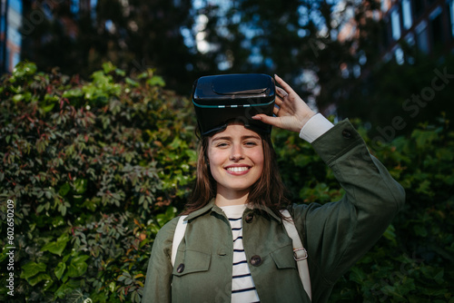Portrait of young woman with virtual reality goggles outdoor.