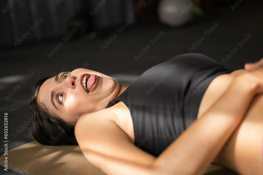 Obraz premium making grimaces, sticking out the tongue lying down when resting from an exercise routine, lifestyle of funny person with natural gestures