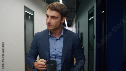 Relaxed employee holding coffee cup closeup. Company ceo walking hallway resting