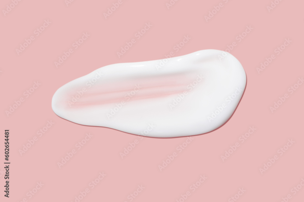A dab of cosmetic cream. Light, smooth surface. Texture of spreadable cream. Liquid cream smear. On a pink background. A dab of cosmetic cream. Light, smooth surface. Texture of spreadable cream. Liquid cream smear. On a pink background.