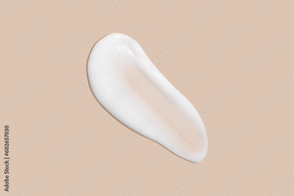 The flowing cream on a beige background. Smudged flowing smear of cosmetic cream. The flowing cream on a beige background. Smudged flowing smear of cosmetic cream.