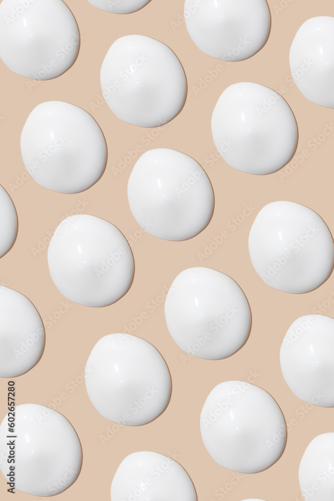 a set of strokes of white cream on a beige background.