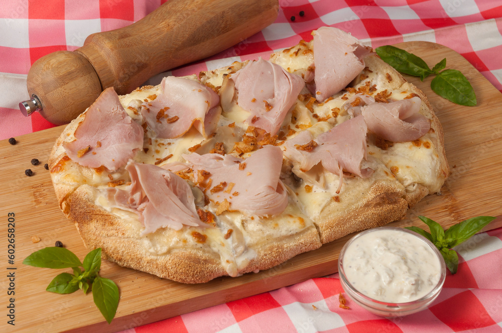 tasty cream-based pizza with ham and mushrooms