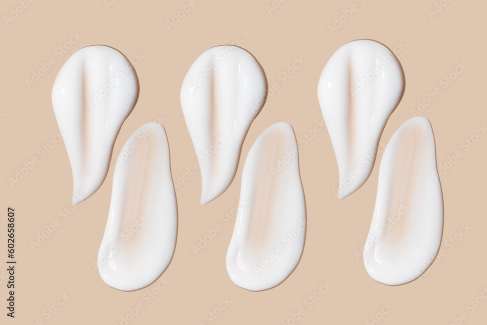a set of strokes of white cream on a beige background. a set of strokes of white cream on a beige background.