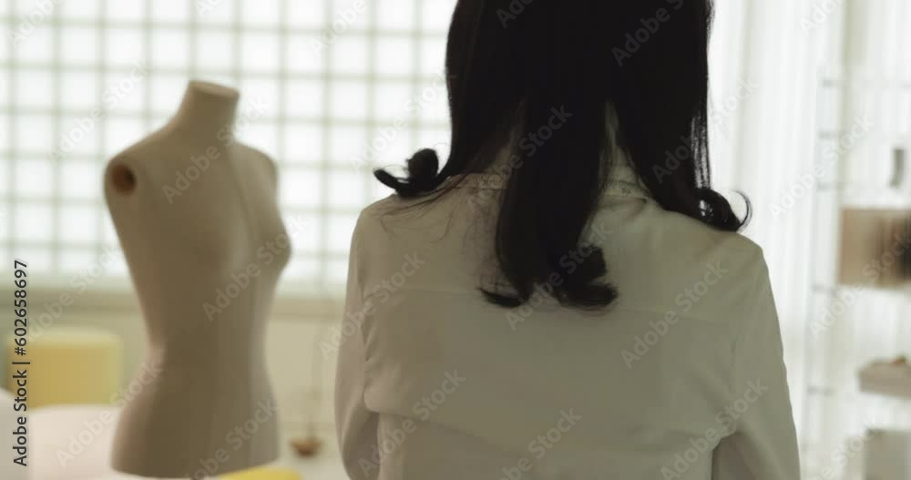 줄자를 목에 두르고 걸어가는 흰색 블라우스를 입은 여성 디자이너 줄자를 목에 두르고 걸어가는 흰색 블라우스를 입은 여성 디자이너