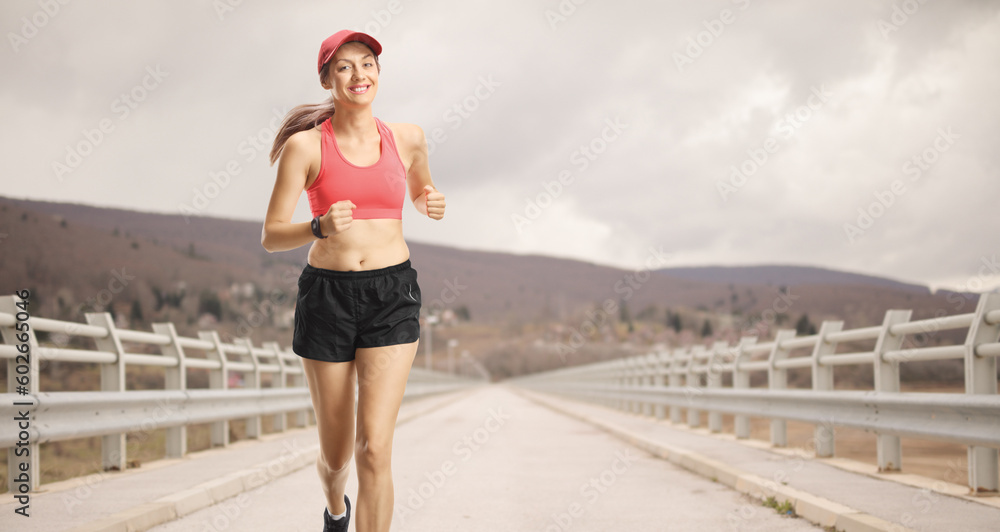 Young smiling woman in sportswear jogging