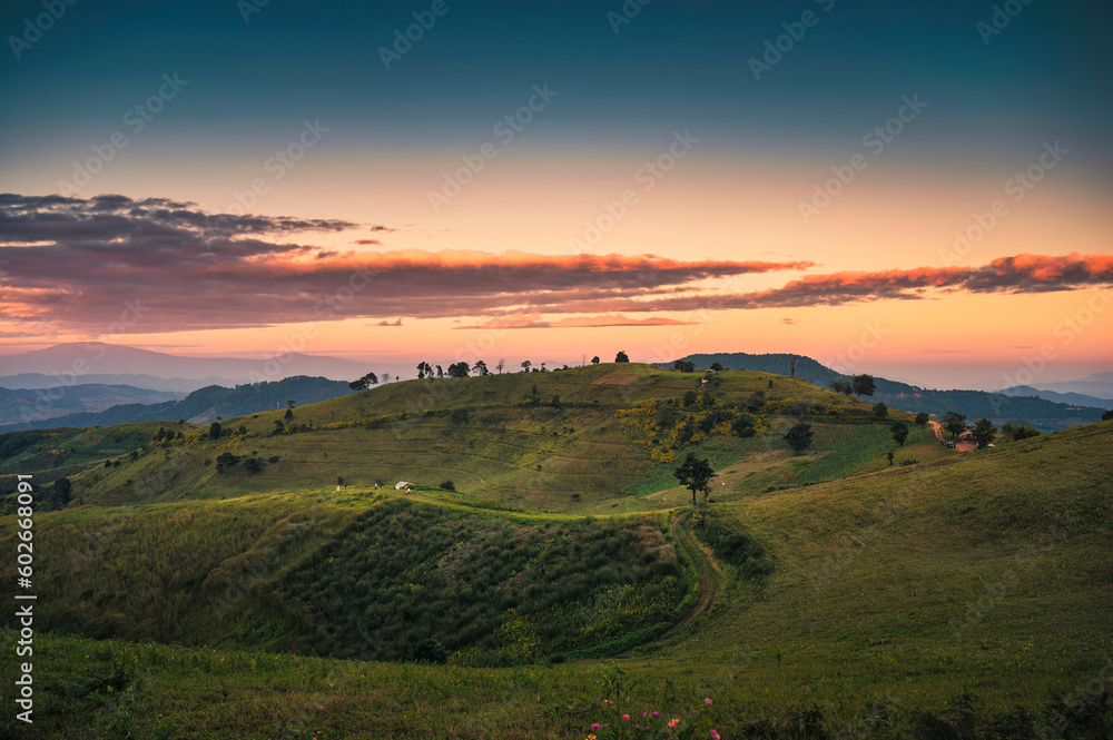 Rural scene of mountain hill with sunset sky in farmland at countryside
