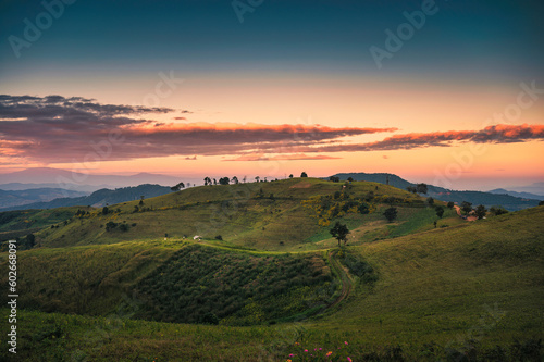 Rural scene of mountain hill with sunset sky in farmland at countryside