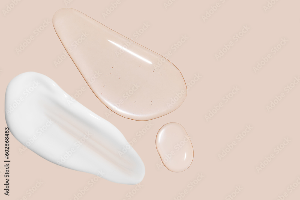 Obraz premium Drops of transparent gel and a dab of white cosmetic cream. On a beige background.