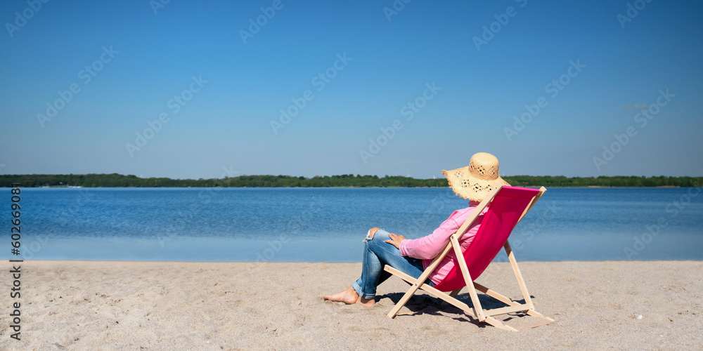 Frau entspannt sich im Liegestuhl am See