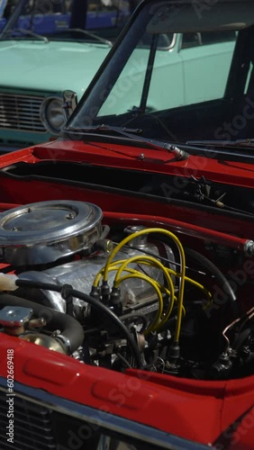Wallpaper Mural Old collectible car in perfect condition without hood stands next to another car on platform under sunlight. Carbureted clean engine with shiny polished chrome parts and high voltage wires. Torontodigital.ca