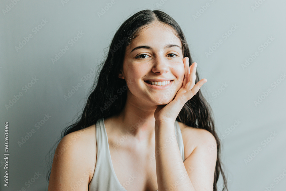 Portrait of model, with hand in face relaxed after dermatology skin treatment. Young adult woman skincare glow from spa rituals, posing with glowing, clean and clear skin and no makeup. Portrait of model, with hand in face relaxed after dermatology skin treatment. Young adult woman skincare glow from spa rituals, posing with glowing, clean and clear skin and no makeup.