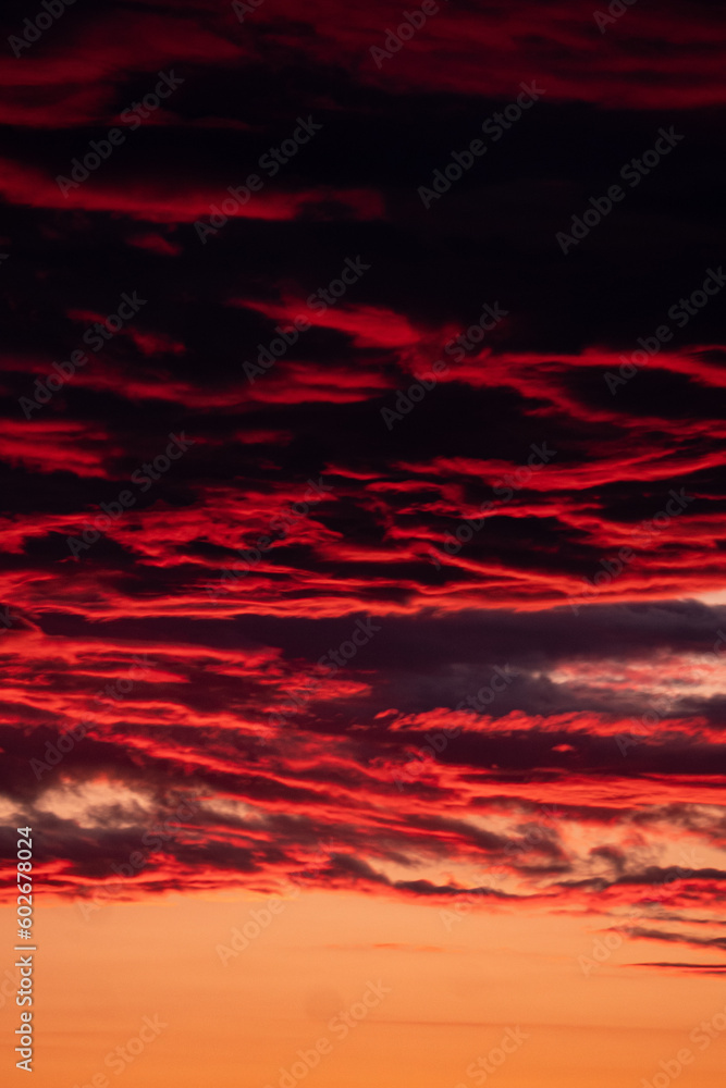 Vibrant sunset colors, dramatic red clouds on sky