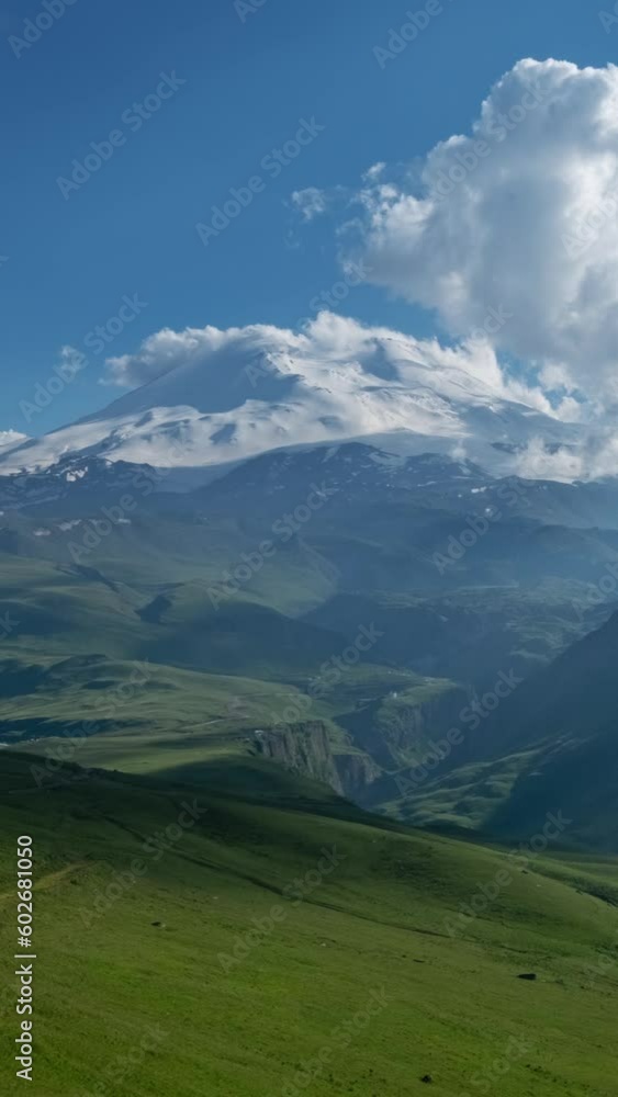 Beautiful view of Mount Elbrus and clouds before sunset, North Caucasus mountains, Russia, timelapse. Vertical video Beautiful view of Mount Elbrus and clouds before sunset, North Caucasus mountains, Russia, timelapse. Vertical video