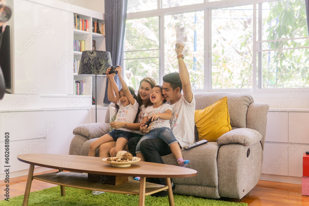 Playful family playing video games together in a living room. Playful family playing video games together in a living room.