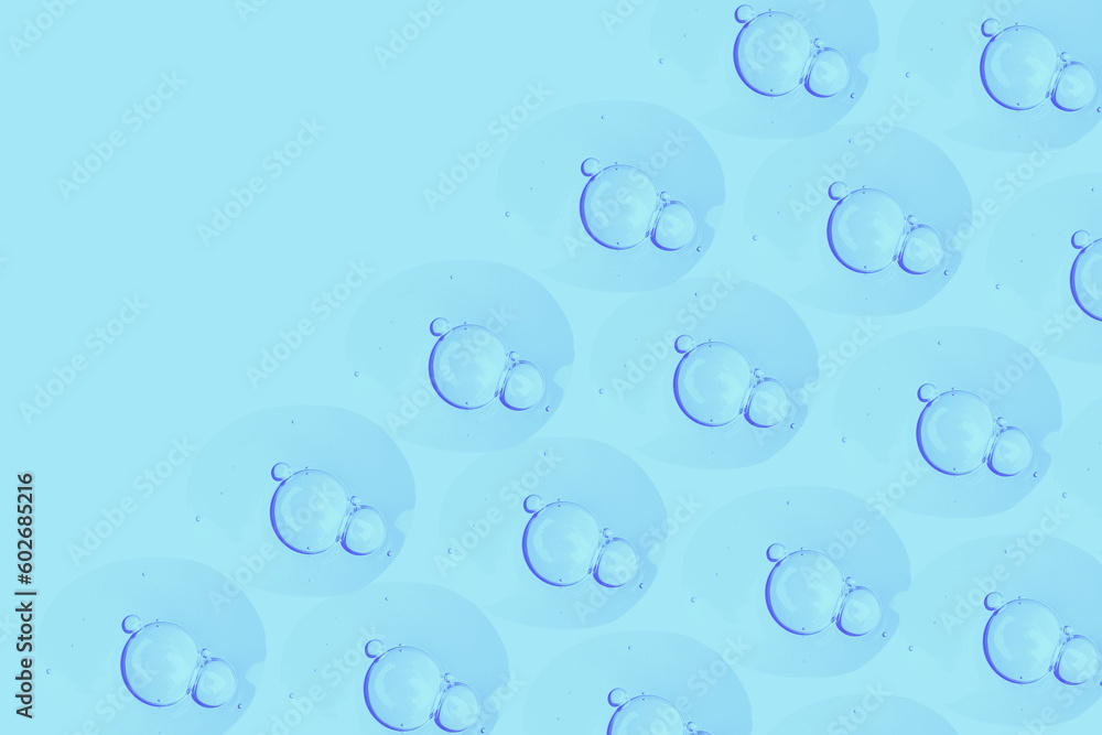 round drops of transparent gel serum on a blue background. gel with bubbles. Water droplets