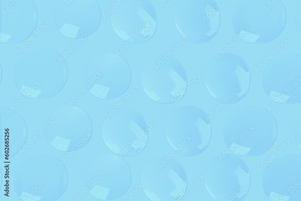 round drops of transparent gel serum on a blue background. gel with bubbles. Water droplets round drops of transparent gel serum on a blue background. gel with bubbles. Water droplets