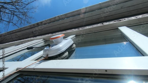 robot vacuum cleaner washes windows on a sunny day, video without filters
