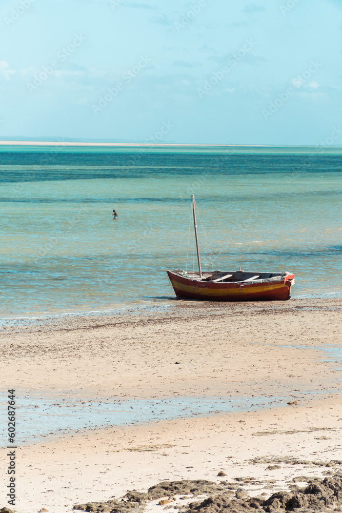 Traditional dhow fishing boat on a tropical white sand beach in vilanculos, Mozambique. Traditional dhow fishing boat on a tropical white sand beach in vilanculos, Mozambique.