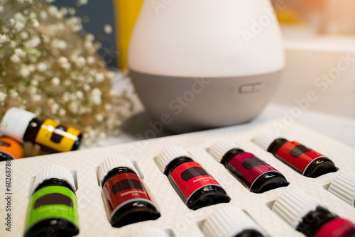 Closeup of essential oils bottles and air diffuser in background 