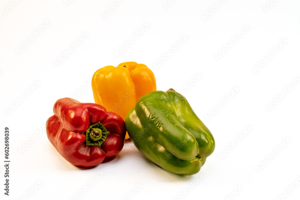 Pimientos de tres colores sobre fondo liso blanco, no gente Pimientos de tres colores sobre fondo liso blanco, no gente
