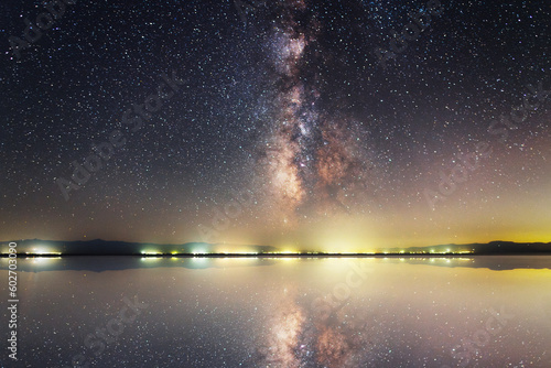 Beautiful night landscape. Bright Milky Way galaxy over the lake with reflection 