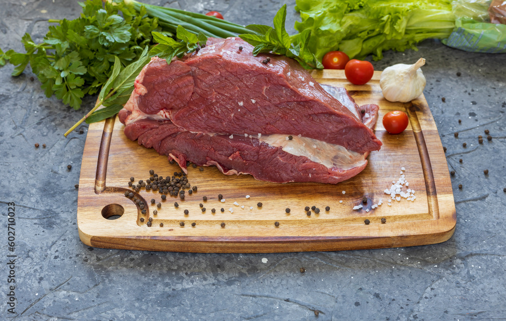 A piece of raw meat close-up on a dark background.