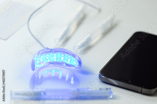 whitening kit at home with LED lamp, on a white background, snow-white smile, dental care, dentistry