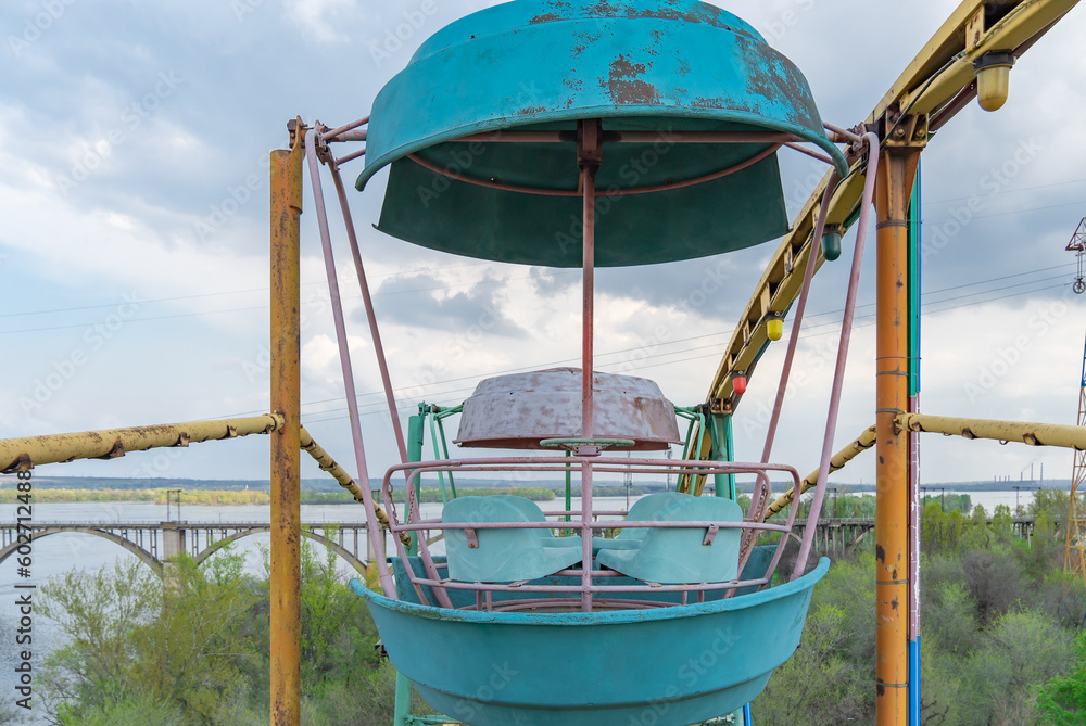 Old colorful ferris wheel in amusement park. Multicolour soviet carousel on blue sky background. Entertainment tall circle rotate in city. Round attractions of holiday for family. Traditional leisure. Old colorful ferris wheel in amusement park. Multicolour soviet carousel on blue sky background. Entertainment tall circle rotate in city. Round attractions of holiday for family. Traditional leisure.
