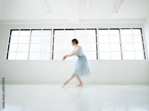窓のある明るい室内でバレエの練習をする女性