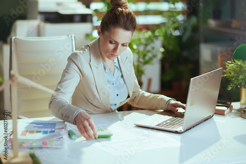 business woman in light business suit in green office