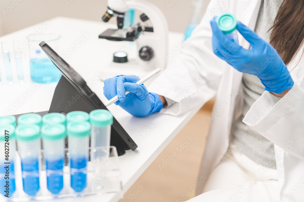 Medical development research laboratory, chemist or science woman scientist student hand holding pipette for test analysis liquid samples, using tablet in lab. Microbiology, analysing for medicine.