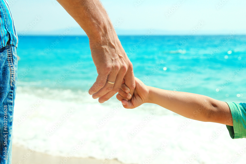 A Hands of a happy parent and child on the seashore on a journey trip in nature A Hands of a happy parent and child on the seashore on a journey trip in nature