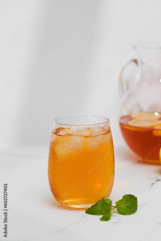 Iced tea with lemon and mint in a glass and in a jug. Summer drinks. Iced tea with lemon and mint in a glass and in a jug. Summer drinks.