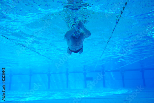 undervater shoot of swimming pool with good looking young swimmer photo