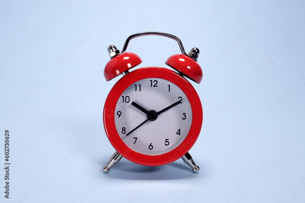 Red alarm clock on a blue background Red alarm clock on a blue background