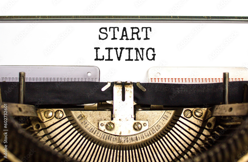 Start living symbol. Concept words Start living typed on beautiful old retro typewriter. Beautiful white background. Business and Start living concept. Copy space.