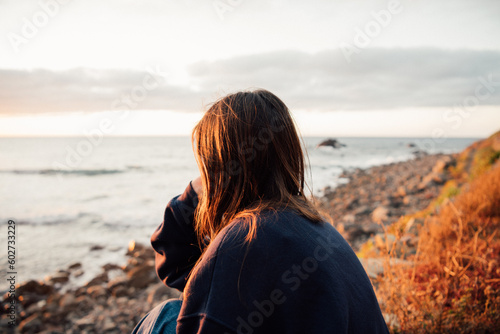 Young woman watching the sunset at a viewpoint