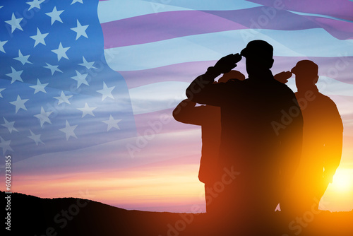 Silhouettes of soldiers saluting on a background of sunset or sunrise and USA flag. Close-up. Greeting card for Veterans Day, Memorial Day, Independence Day. America celebration.