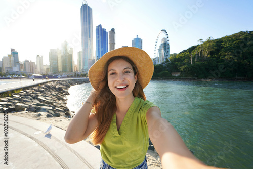 Photography Brazilian woman takes selfie picture in Balneario Camboriu on sunset, Brazil