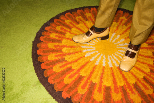 Bild auf Leinwand Close-up of Caucasian mid-adult male feet in vintage shoes against sunburst rug