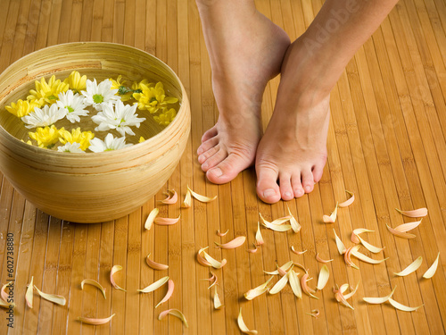 feet near a basin with flowers and water