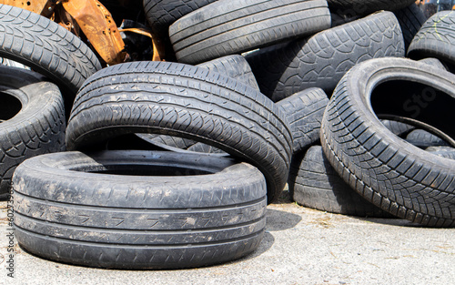 Industrial dump for the processing of used tires and rubber tires. Pile of old tires and wheels for rubber recycling. Tire dump. Recycling of used tires. Produced reclaimed tire rubber.