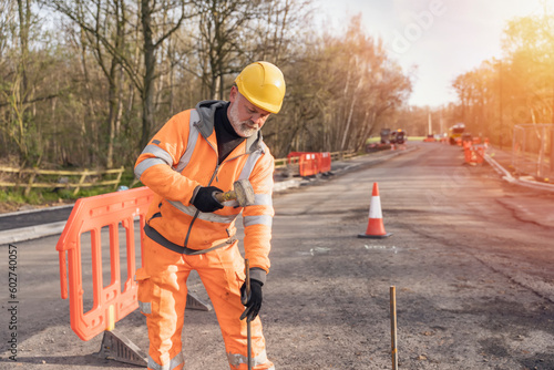 Bilde på lerret Builder knocking down road setting out steel pins with lump hammer during roadworks