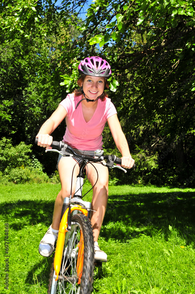 Portrait of a teenage girl riding a bicycle in summer park outdoors Portrait of a teenage girl riding a bicycle in summer park outdoors