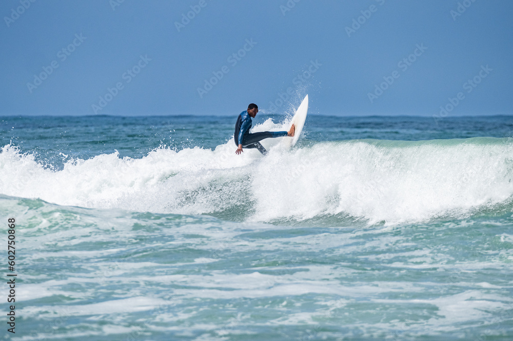 Young athletic surfer rides the wave