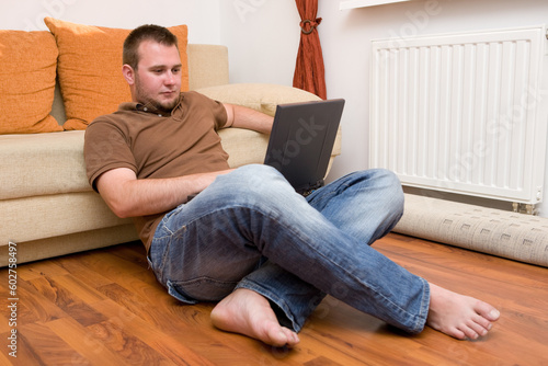 happy man sitting on sofa with laptop