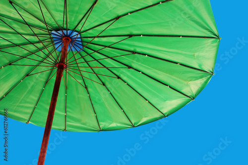 Bright green umbrella against a blue sky - travel and tourism